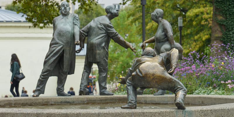 Gott im Alltag - Ein Brunnen, an dem vier menschliche Skulpturen aus Bronze den Kreislauf des Geldes symbolisch zum Ausdruck bringen